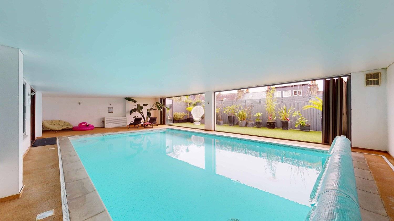 Spacious indoor pool hall in Streatham, SW16 set under blue painted ceilings with garden views, ideal for swimwear shoots, Love Locations.