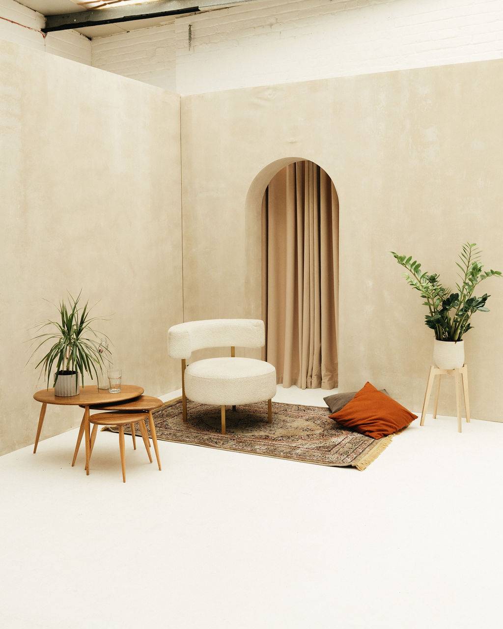 Brushed plaster arched wall with soft curtain styled as an elegant event space at Brixton Warehouse Love Locations.
