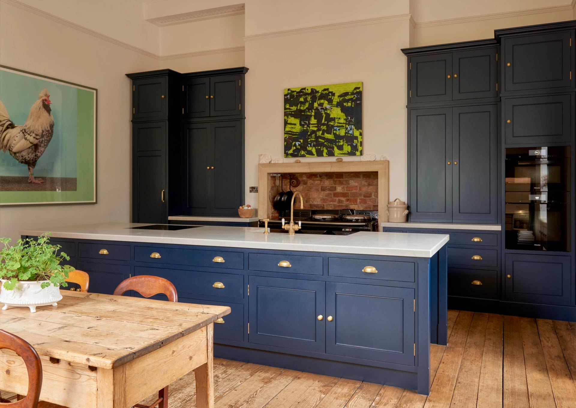 Luxury country kitchen featuring dark navy shaker cabinetry, a large kitchen island, and marble worktops, perfect for culinary brand advertising via Love Locations.