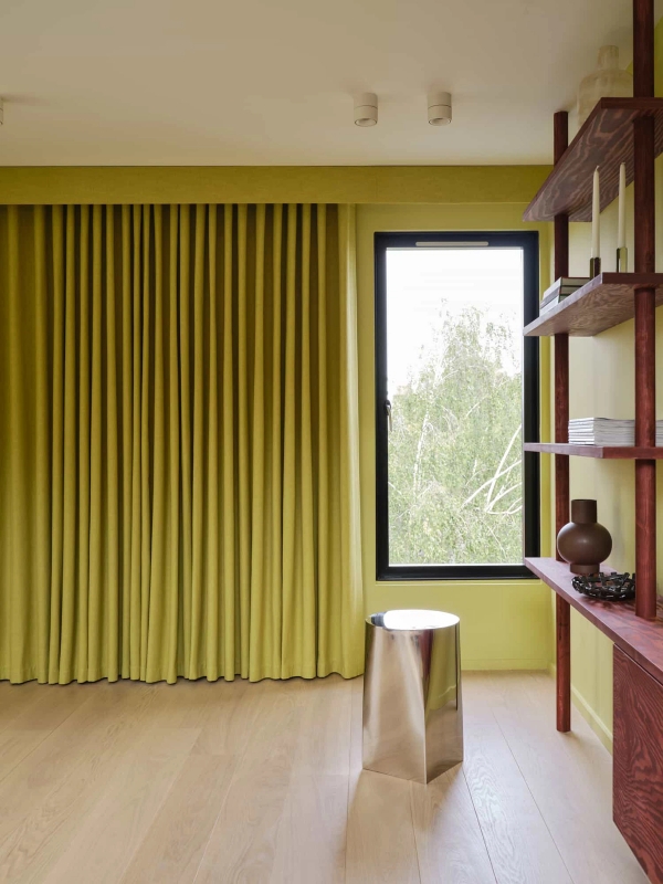 Love Locations monochrome color room SE23: Light streaming through a modern black window frame into a chartreuse green decorated study space, ideal for editorial photography.