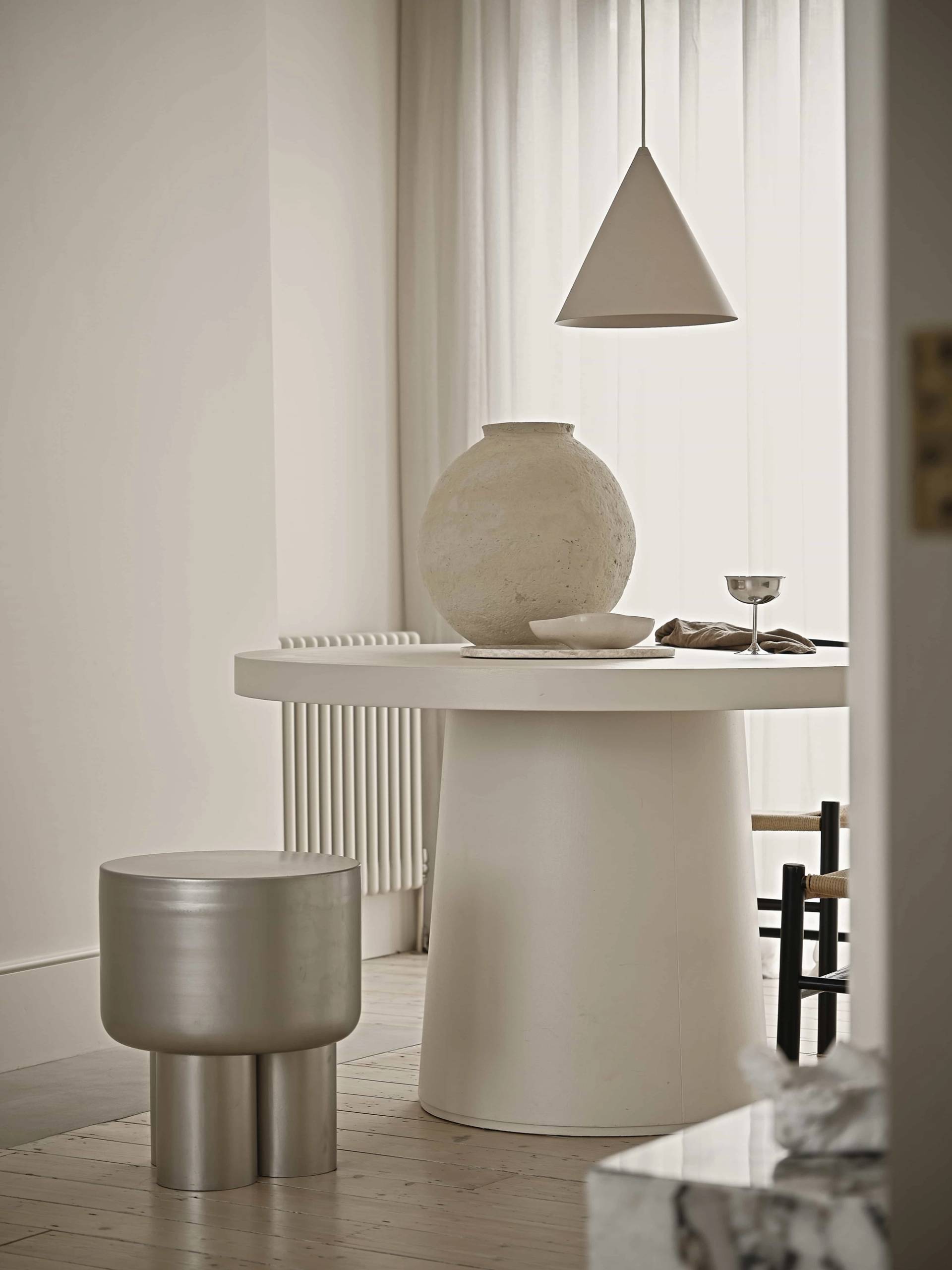 Editorial dining room setup in Waltham Forest, E4 with a cream round pedestal table, ceramic vase, and minimalist lighting, Love Locations E4.