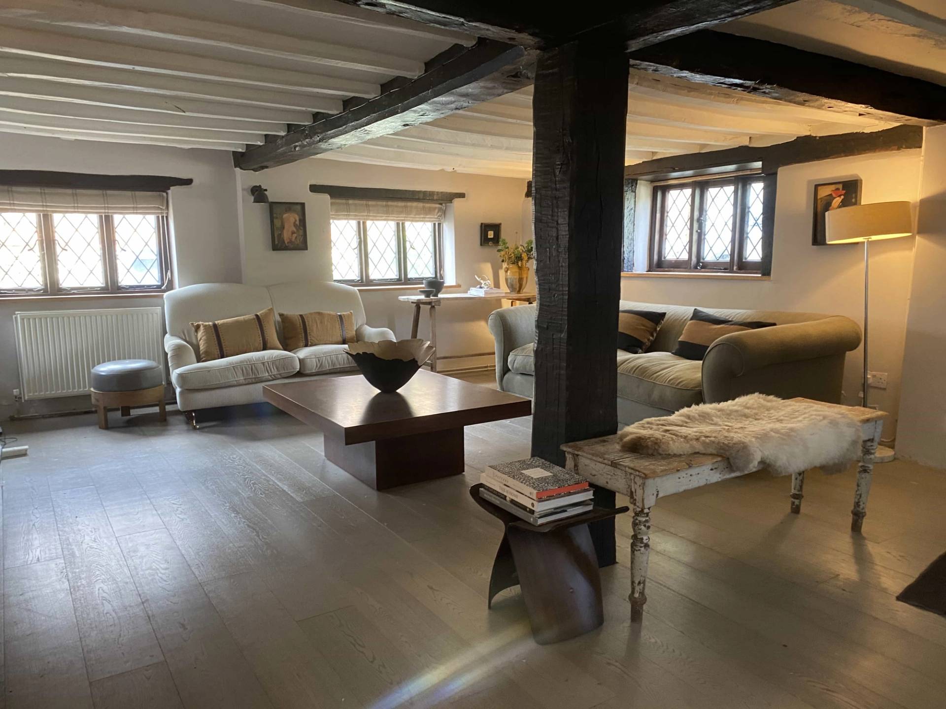 Spacious oak-beamed Tudor living room location featuring white walls, low ceilings, and comfortable seating, ideal for period drama scenes, Love Locations.