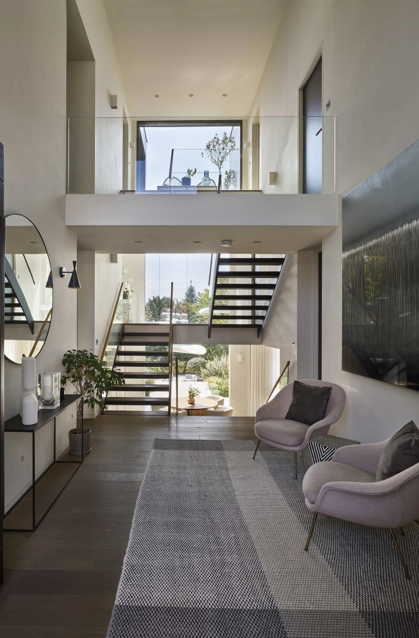 Grand double-height entrance hall with contemporary armchairs and designer lighting for television production, Love Locations.