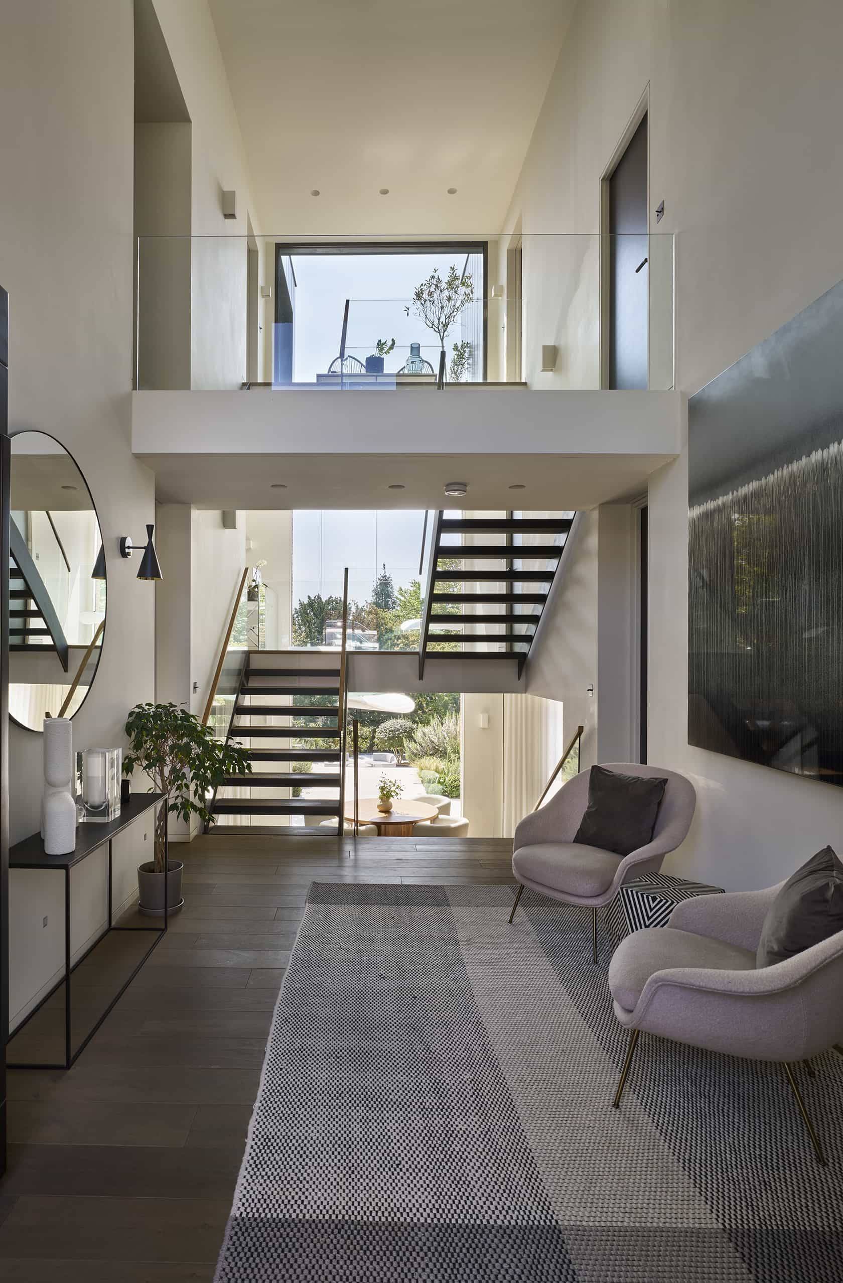 Grand double-height entrance hall with contemporary armchairs and designer lighting for television production, Love Locations.