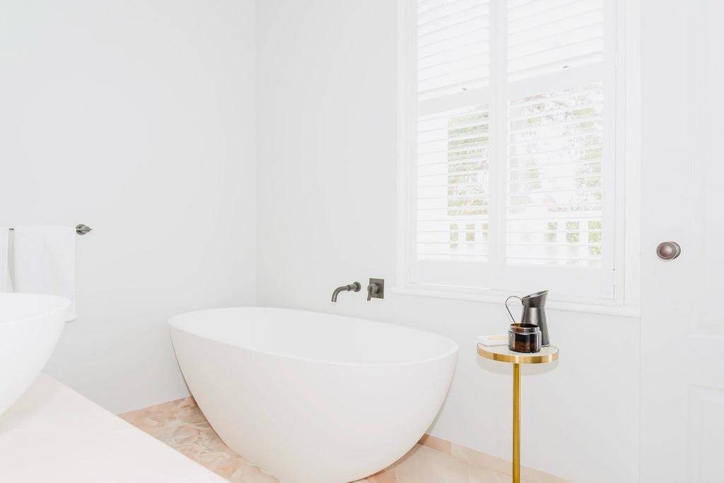 Contemporary wet room bathroom with a freestanding oval soaking tub and brass standing mixer tap, Love Locations TW11.
