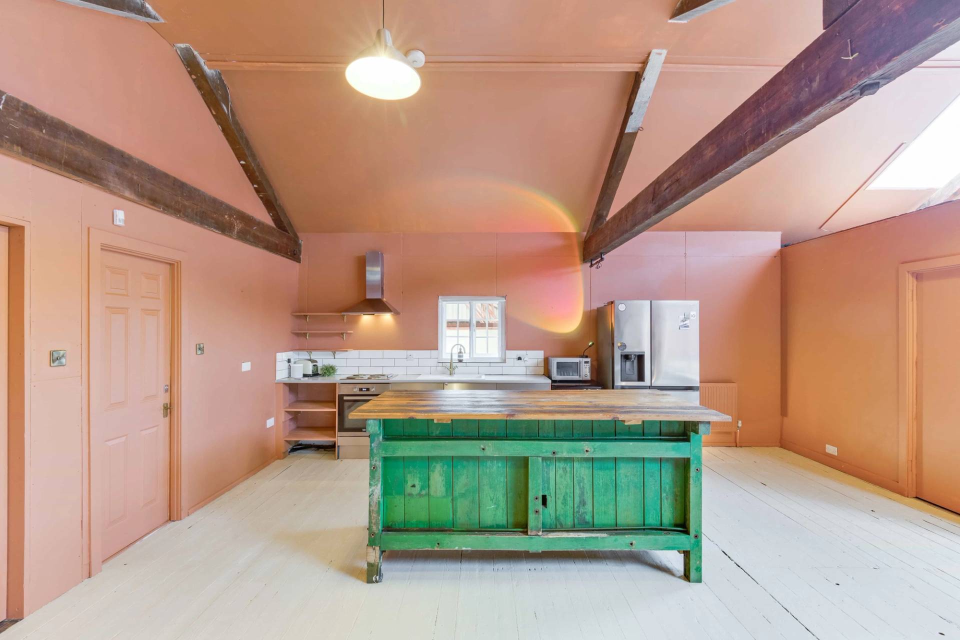 Bespoke rustic wooden kitchen island unit set in a spacious, light-filled open-plan loft studio, Love Locations.
