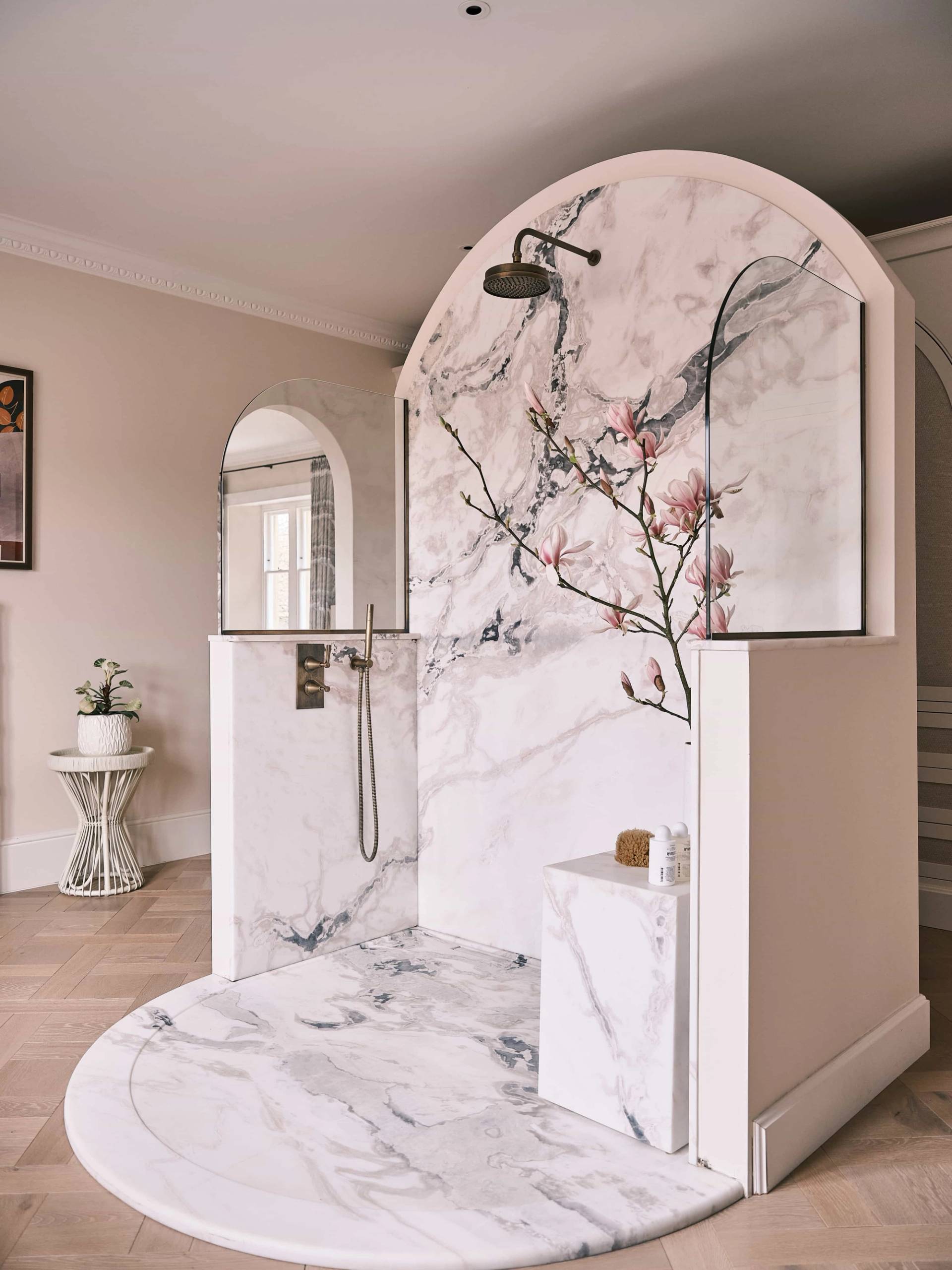 Walk-in shower enclosure lined with cherry blossom marble slab tiles and dark metal fittings, perfect for luxury skincare commercials, Love Locations OX7.