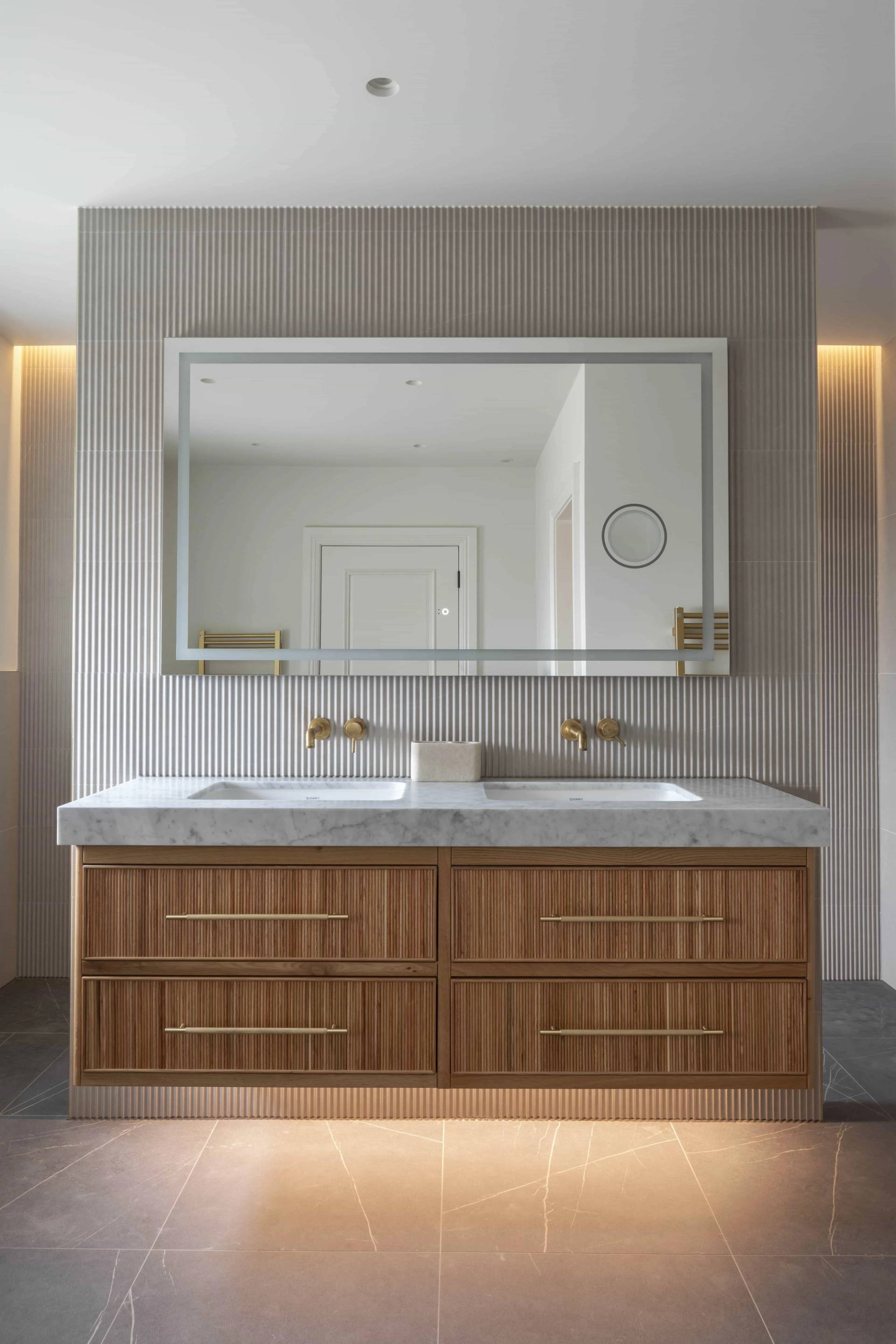 Master bathroom double vanity with fluted wood cabinets, white marble sinks, and LED mirror, Love Locations HP18.