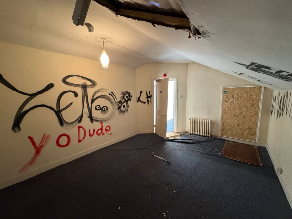 Sloped attic bedroom location room covered in street art style graffiti with an open doorway, listed on Love Locations.