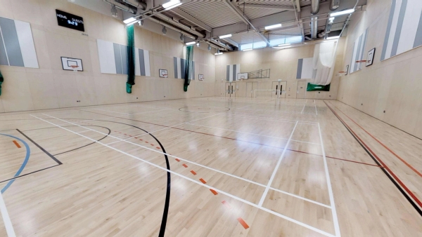 Expansive multi-sports gymnasium filming location featuring high ceilings and industrial lighting in South London, Love Locations.