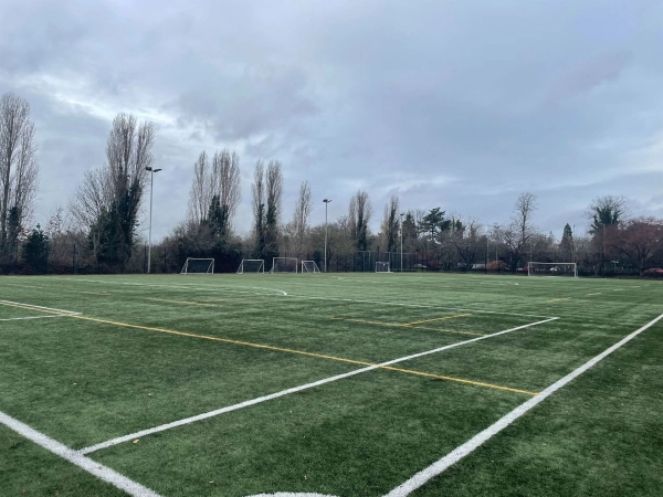 Love Locations commercial sports ground RG30: Wide-open all-weather sports facility with perimeter fencing, ideal for action sequences, commercial video, and lifestyle photography.