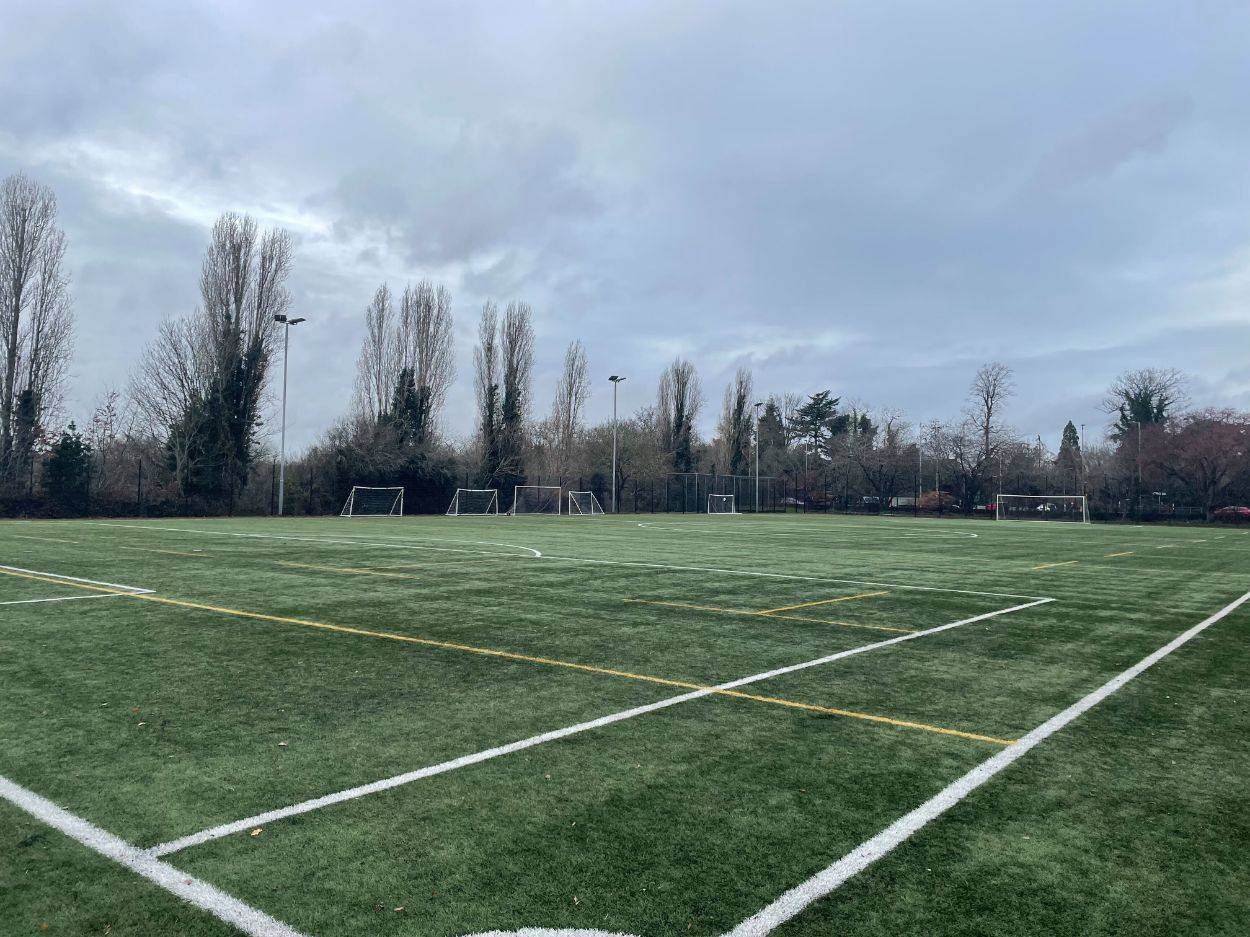 Love Locations commercial sports ground RG30: Wide-open all-weather sports facility with perimeter fencing, ideal for action sequences, commercial video, and lifestyle photography.