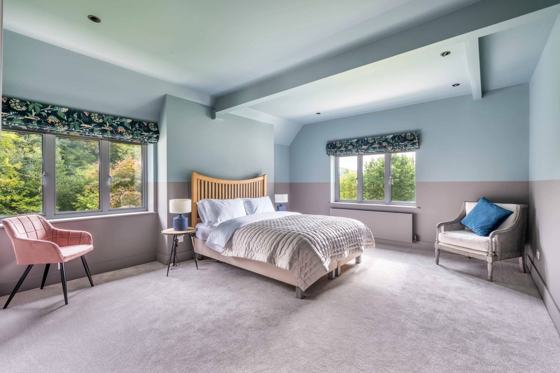 Dual-tone blue and grey guest bedroom suite with plush carpeting and natural light, Love Locations.