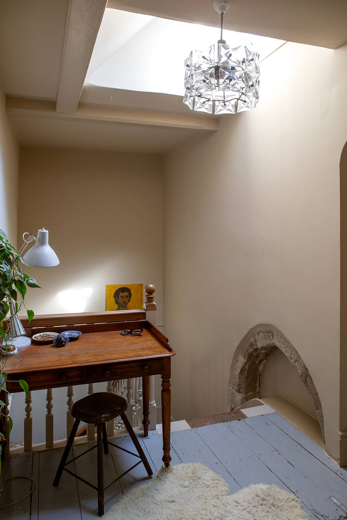 Small wooden writing desk set in a neutral hallway alcove under ceiling skylights, Love Locations ME13.