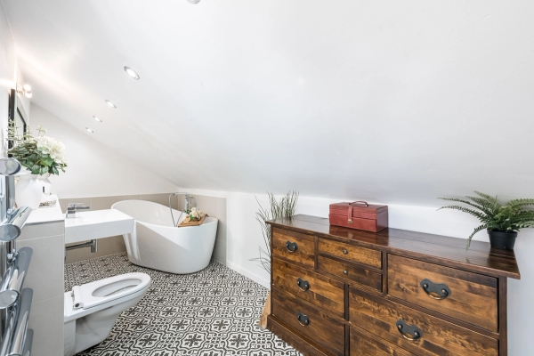 Bespoke bathroom shoot location with a freestanding oval bath, vintage wooden dresser, and mosaic tiled floor, Love Locations.