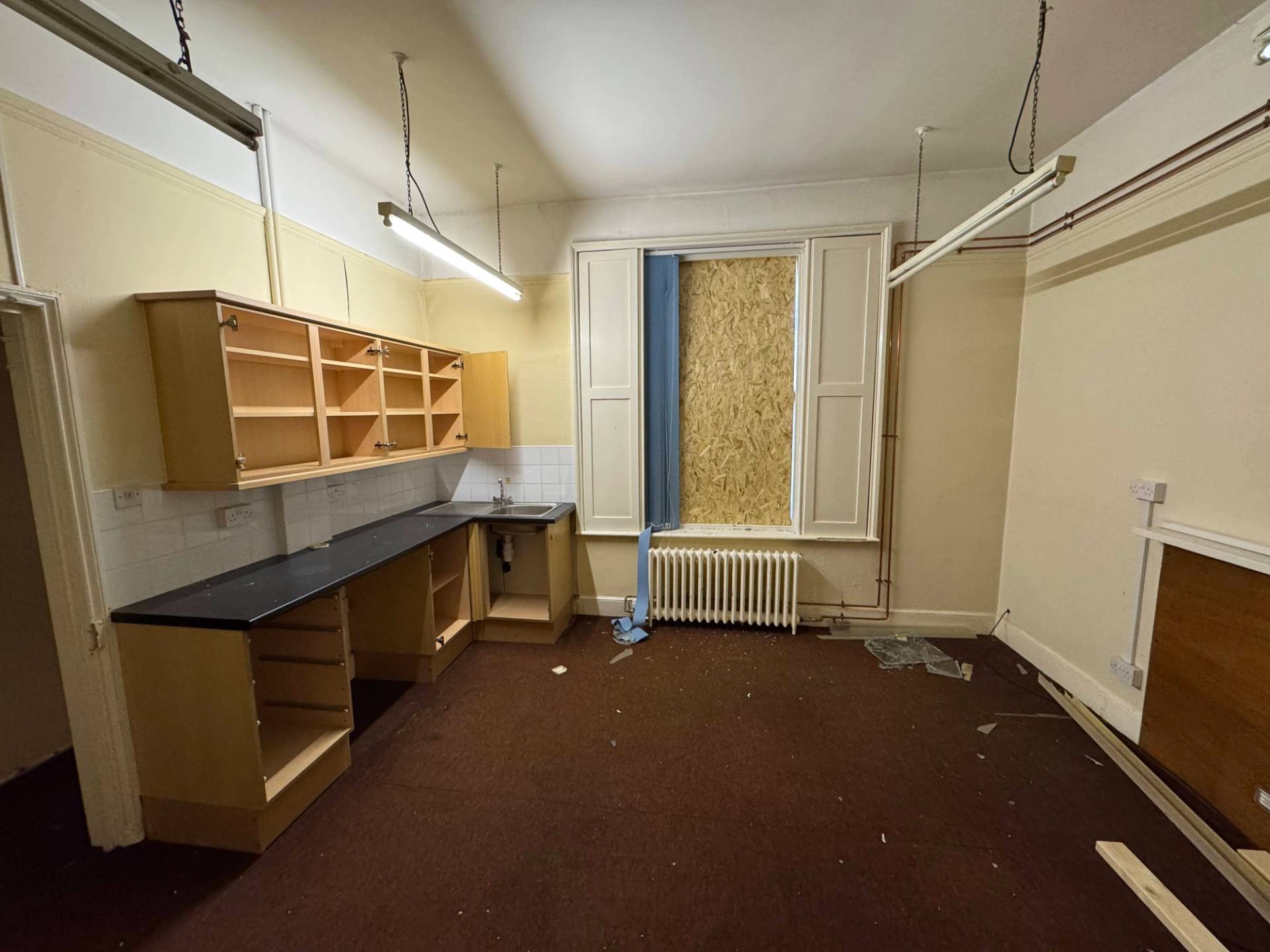 Old laboratory or schoolhouse kitchen studio setup featuring wooden storage cabinets and dark worktops, Love Locations.