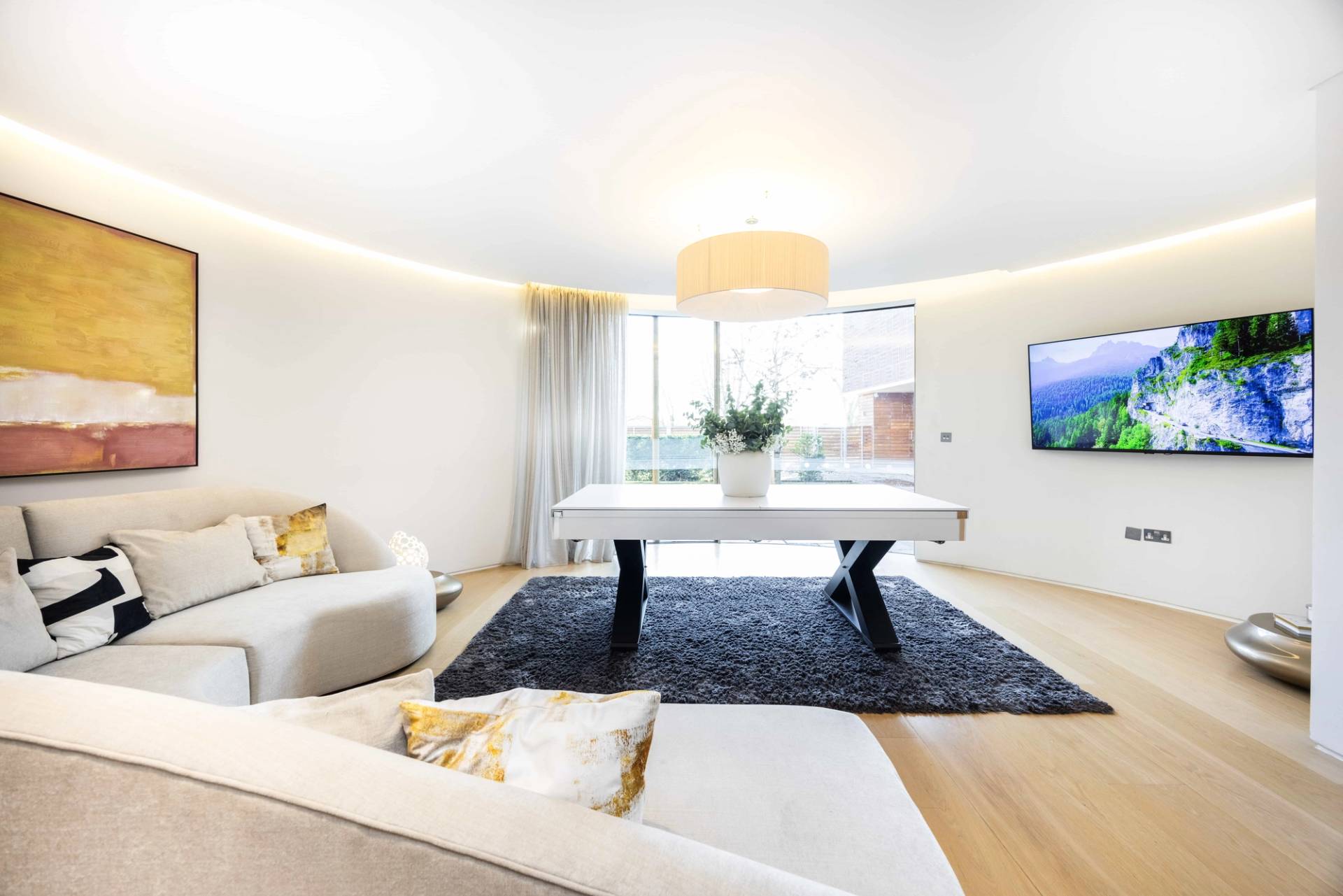 Versatile games room styled with a ping pong table top attachment and curved white sectional sofa, Love Locations WD7.