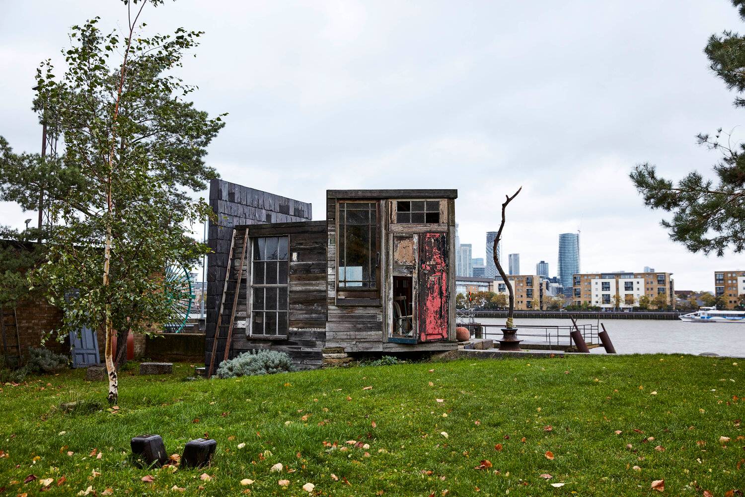 Rustic timber riverside outbuilding and garden set along the River Thames with London skyline views, ideal for creative pop-up events and film productions, Love Locations.