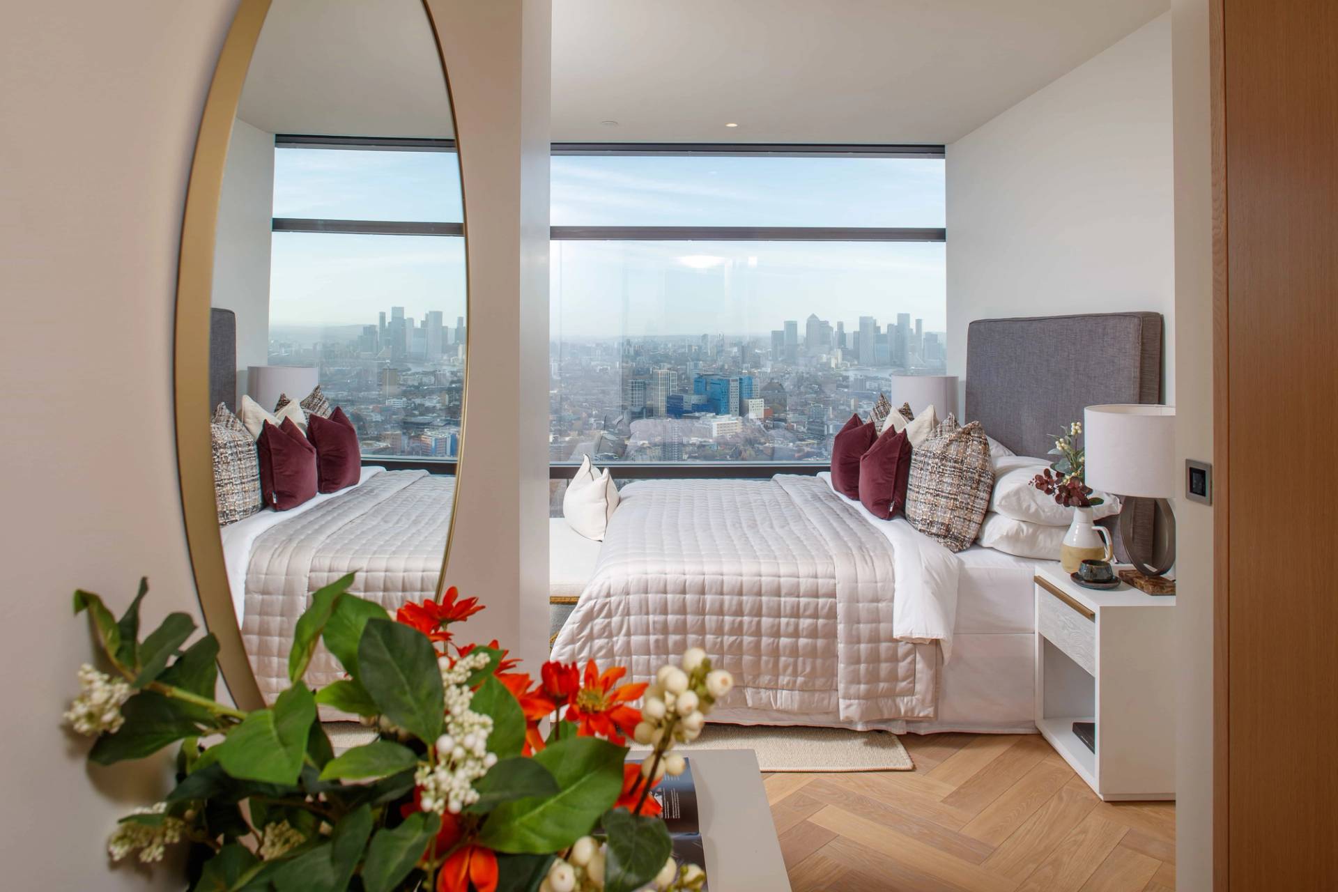 Reflected mirror view of a high-rise penthouse bedroom highlighting expansive City of London skyline views, perfect for editorial fashion lookbooks, Love Locations.