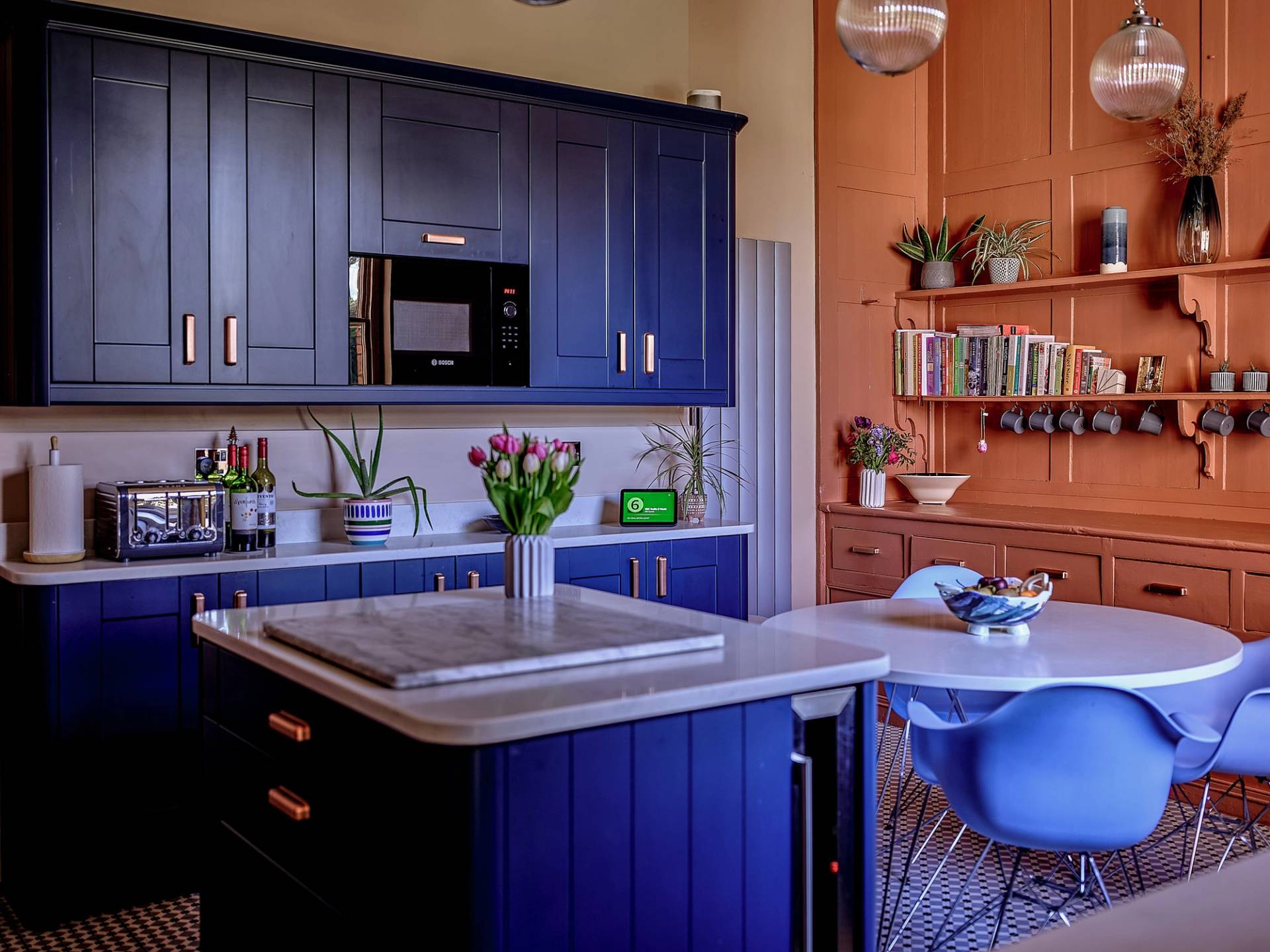 Bold cobalt blue kitchen island with a wood-lined extractor canopy hood and terracotta orange wall accents in Faversham, ideal for food editorial filming, Love Locations ME13.