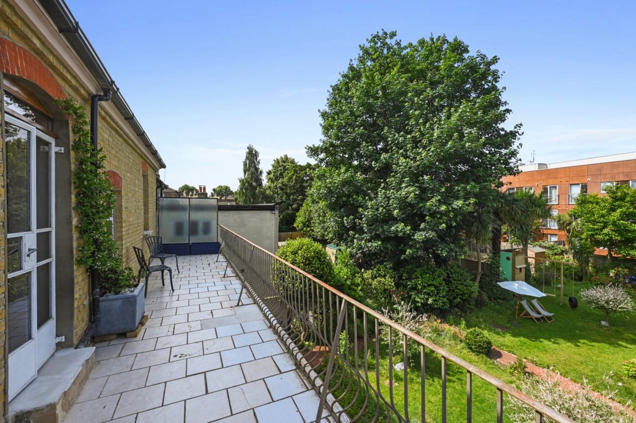 Paved balcony terrace overlooking lush green residential backyards, perfect for outdoor lifestyle filming, Love Locations E7.