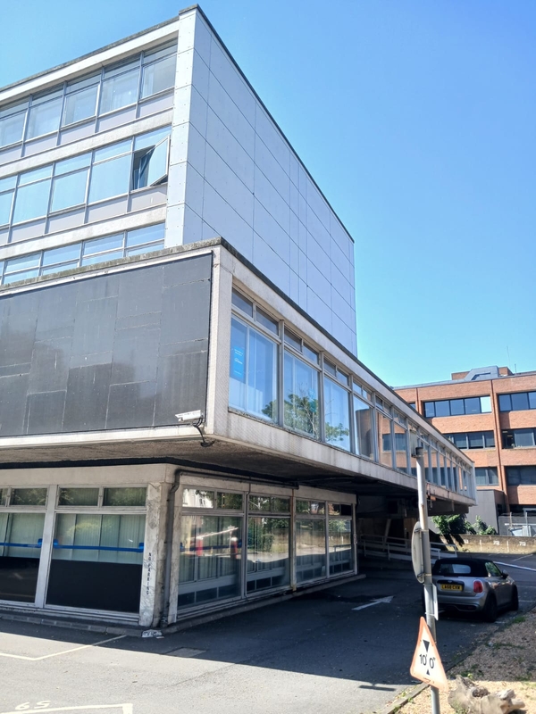 Modernist 1960s or 1970s commercial architecture for film and TV shoots in Watford WD18 by Love Locations, featuring a concrete exterior and prominent glass windows.