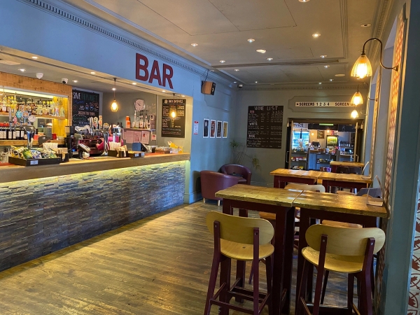 Broad interior view showing tall wooden bar tables, high stools, and the main order counter inside The Ritzy Cafe commercial venue hire in Brixton SW2 through Love Locations.