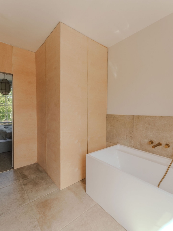 Architectural bathroom layout showing warm wooden panel walls and a deep soaking tub, ideal for wellness brand advertising, Love Locations SW9.