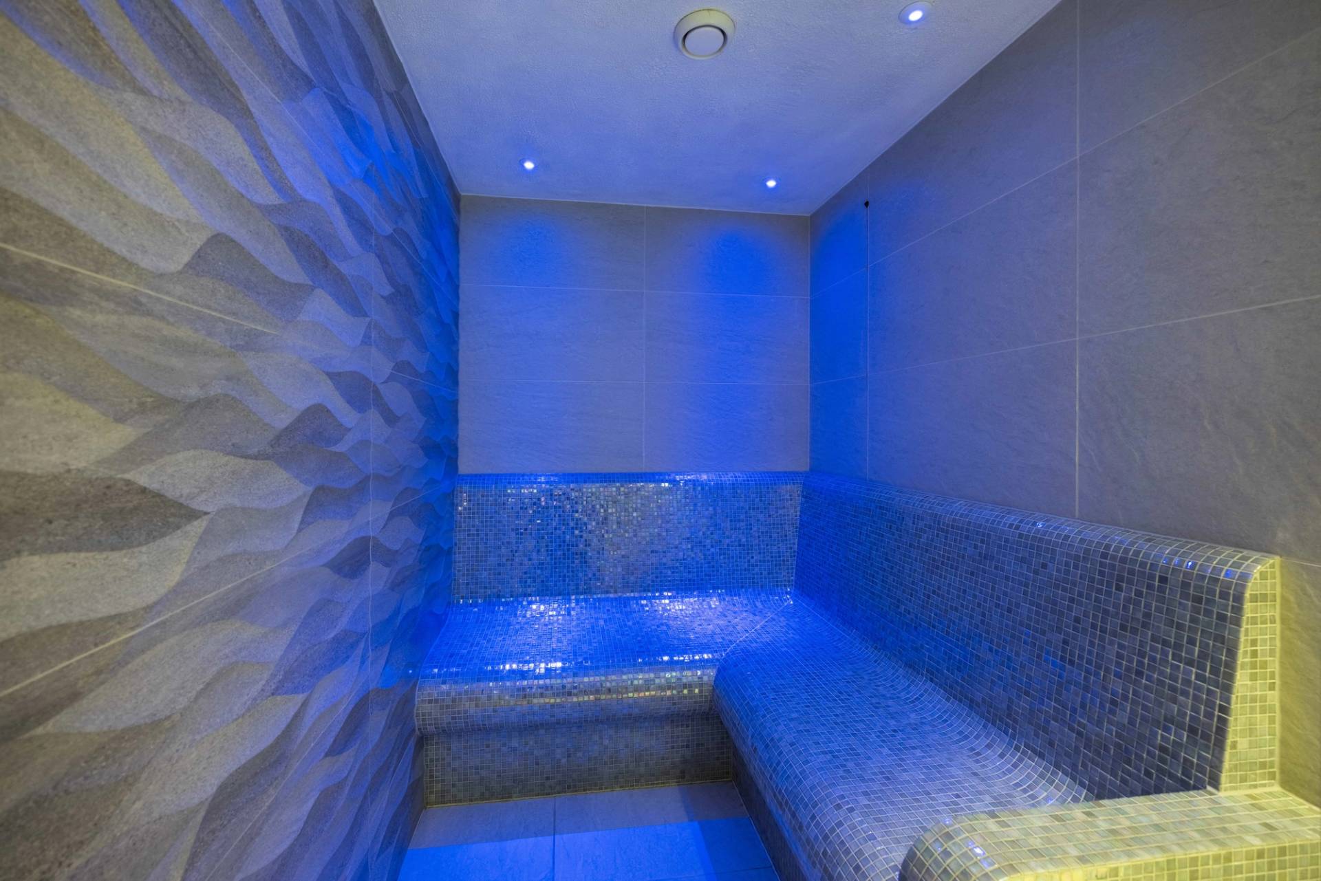 Spa room steam shower with blue ambient lighting and mosaic tile seating, Love Locations WD7.