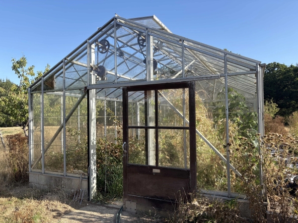 Industrial greenhouse glasshouse structure with sliding metal doors on a farm location in Lewes, Love Locations BN8.