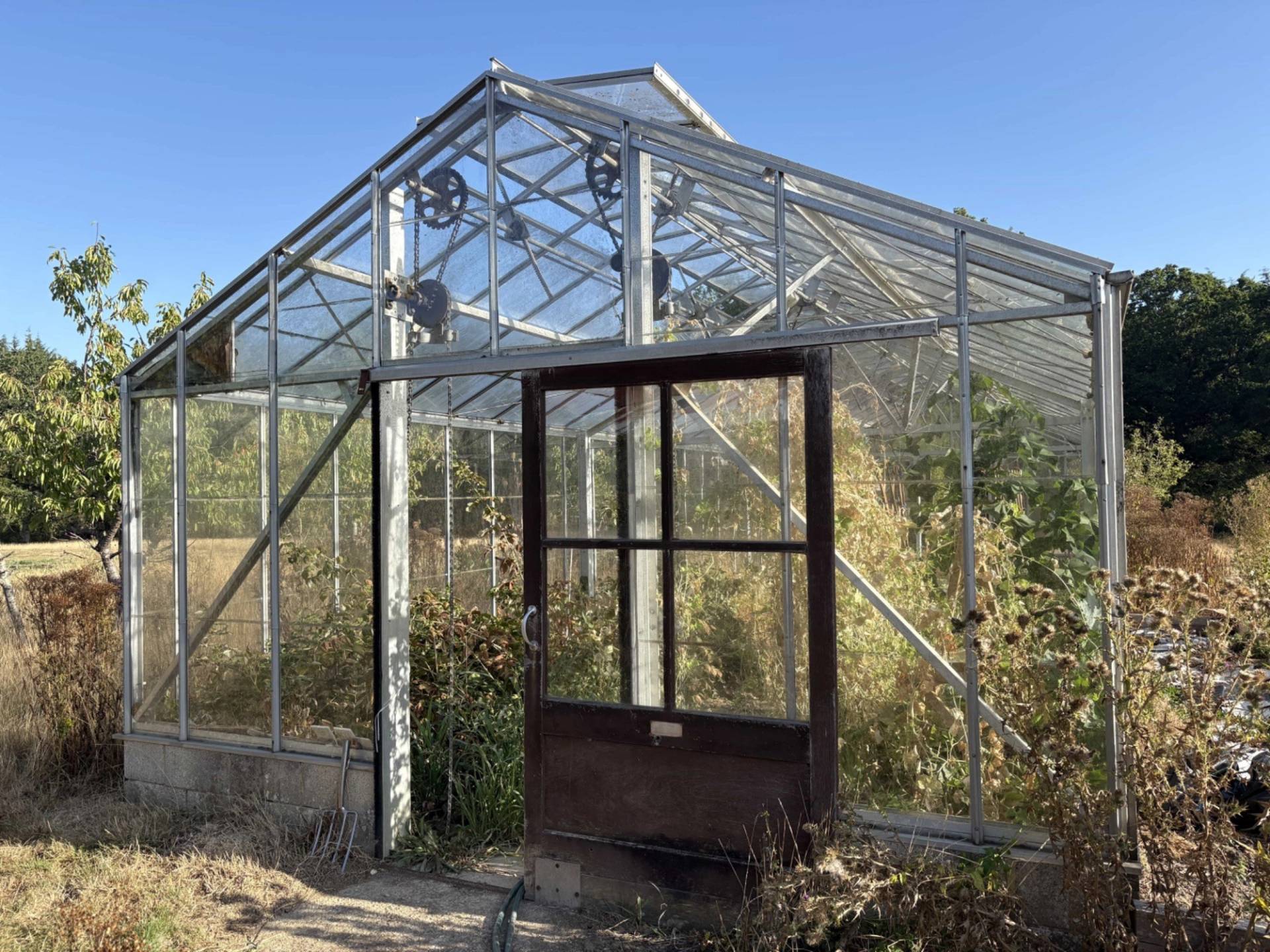Industrial greenhouse glasshouse structure with sliding metal doors on a farm location in Lewes, Love Locations BN8.