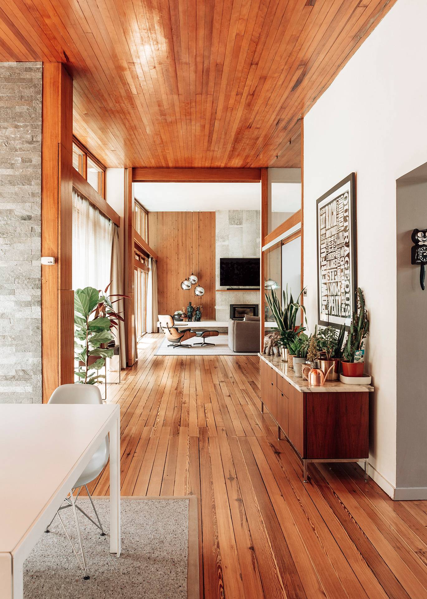 Mid-century modern dining and living open-plan layout in Bromley showcasing rich wood tones and minimalist furniture, Love Locations.