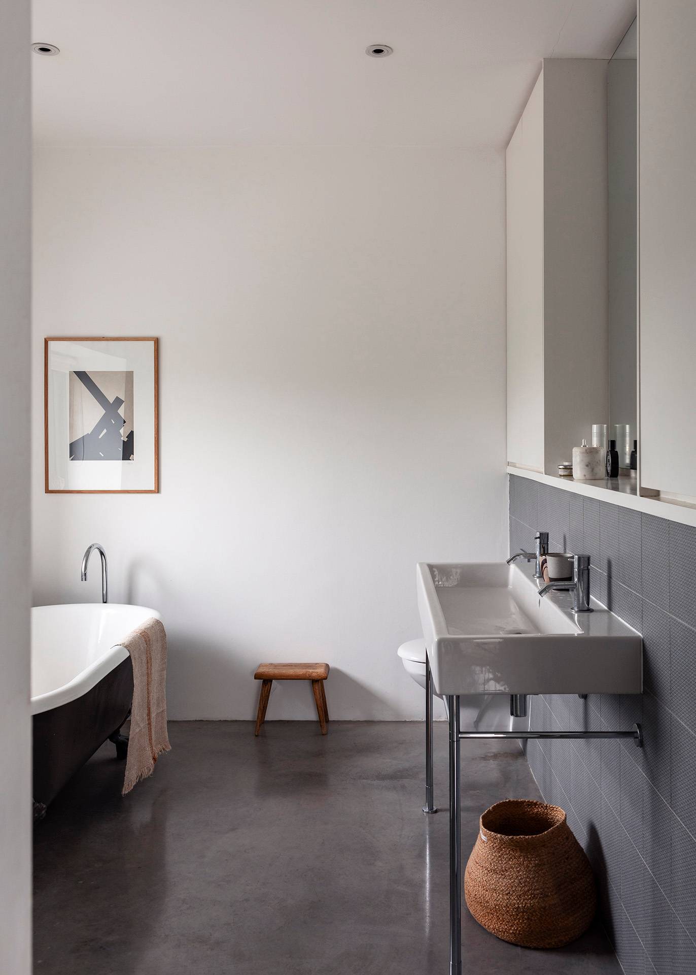 Minimalist bathroom featuring a freestanding white bathtub, double trough sink, and grey slate wall panelling, Love Locations SN8.