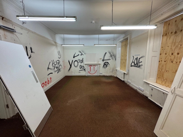Symmetrical view of a graffiti-covered room facing a blocked-off period fireplace mantlepiece, Love Locations Beeston.