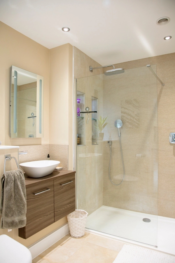 Modern en-suite bathroom filming location featuring a floating wooden vanity sink unit and a large glass walk-in shower, Love Locations.