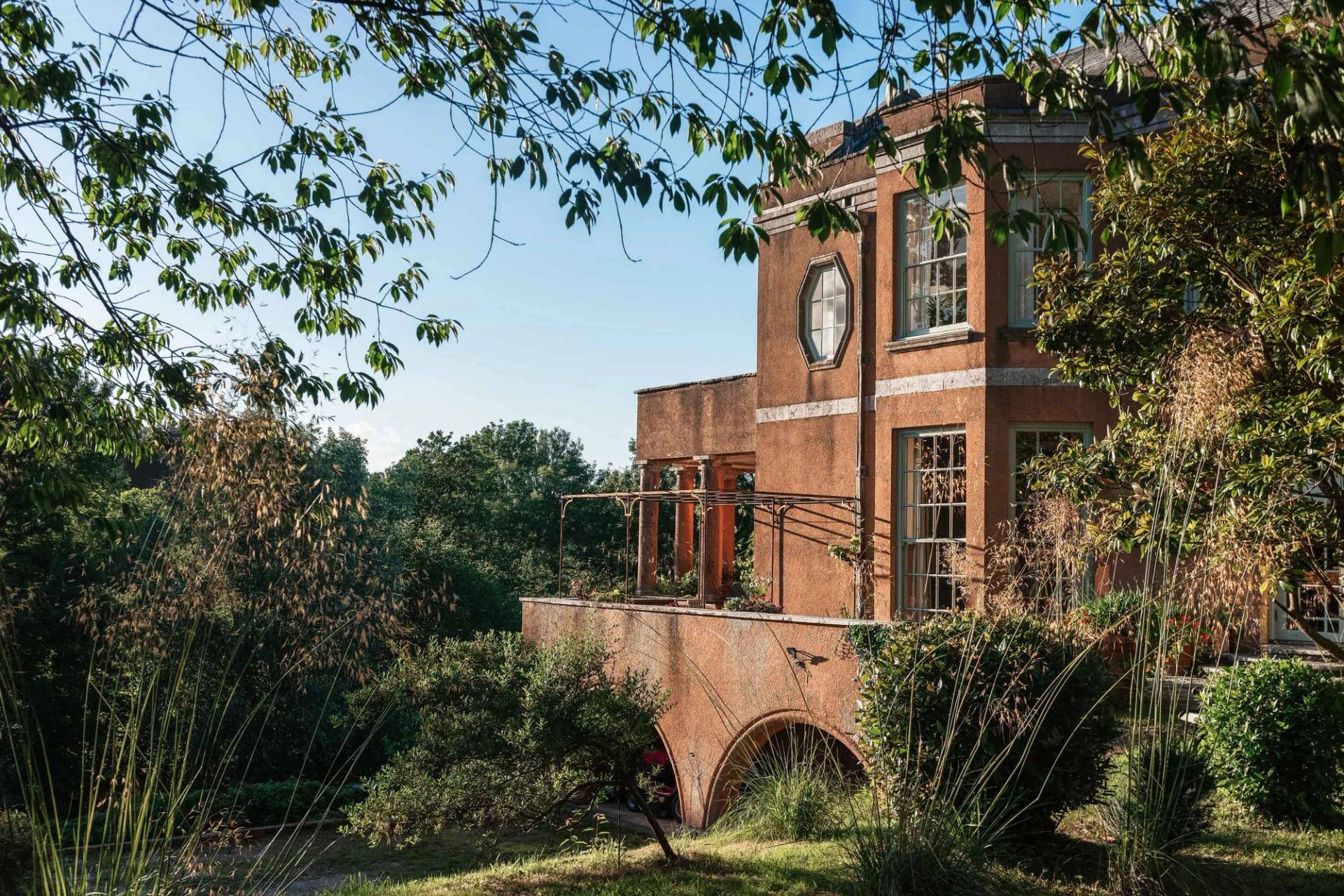 Grand red brick country estate exterior film location in Totnes Devon TQ12 from Love Locations, showing classical architectural details and surrounding gardens.