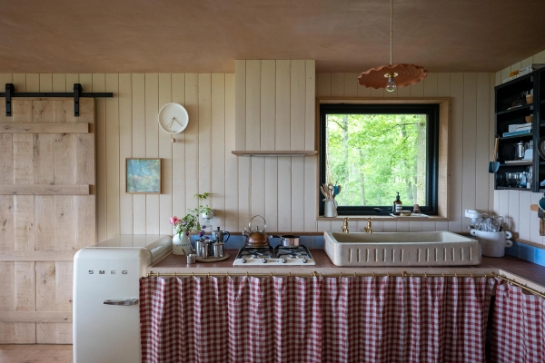 Rustic kitchen location space in Herefordshire, HR4 8ls, featuring cream shiplap walls, a gas hob, and a red-checked sink skirt, perfect for cottagecore lifestyle brand shoots via Love Locations.
