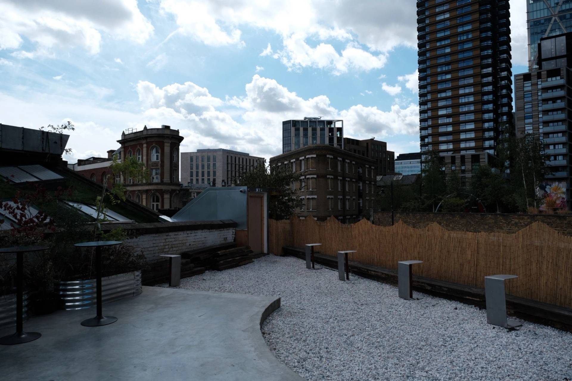 Rooftop gravel courtyard location with wooden boundary fences and East London city skyline backdrop by Love Locations.