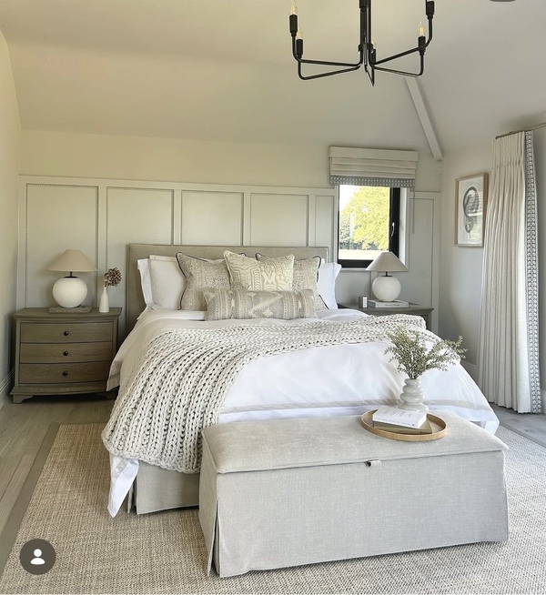 Luxury master bedroom film location in Essex CM4 by Love Locations, featuring wall panelling, a plush upholstered bed with neutral bedding, and an upholstered footrest bench.