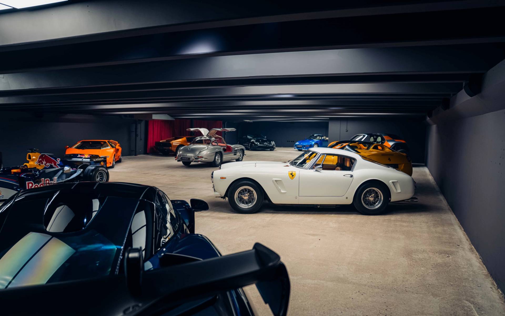Classic white Ferrari and black hypercars inside a spacious underground bunker film location in Brentford TW8 through Love Locations.