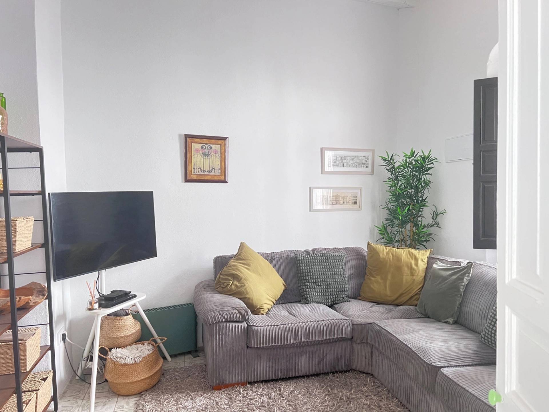 Modern corner sofa seating nook film location in Jimena de la Frontera Cádiz from Love Locations, featuring neutral walls, wood accents, and small framed wall art.