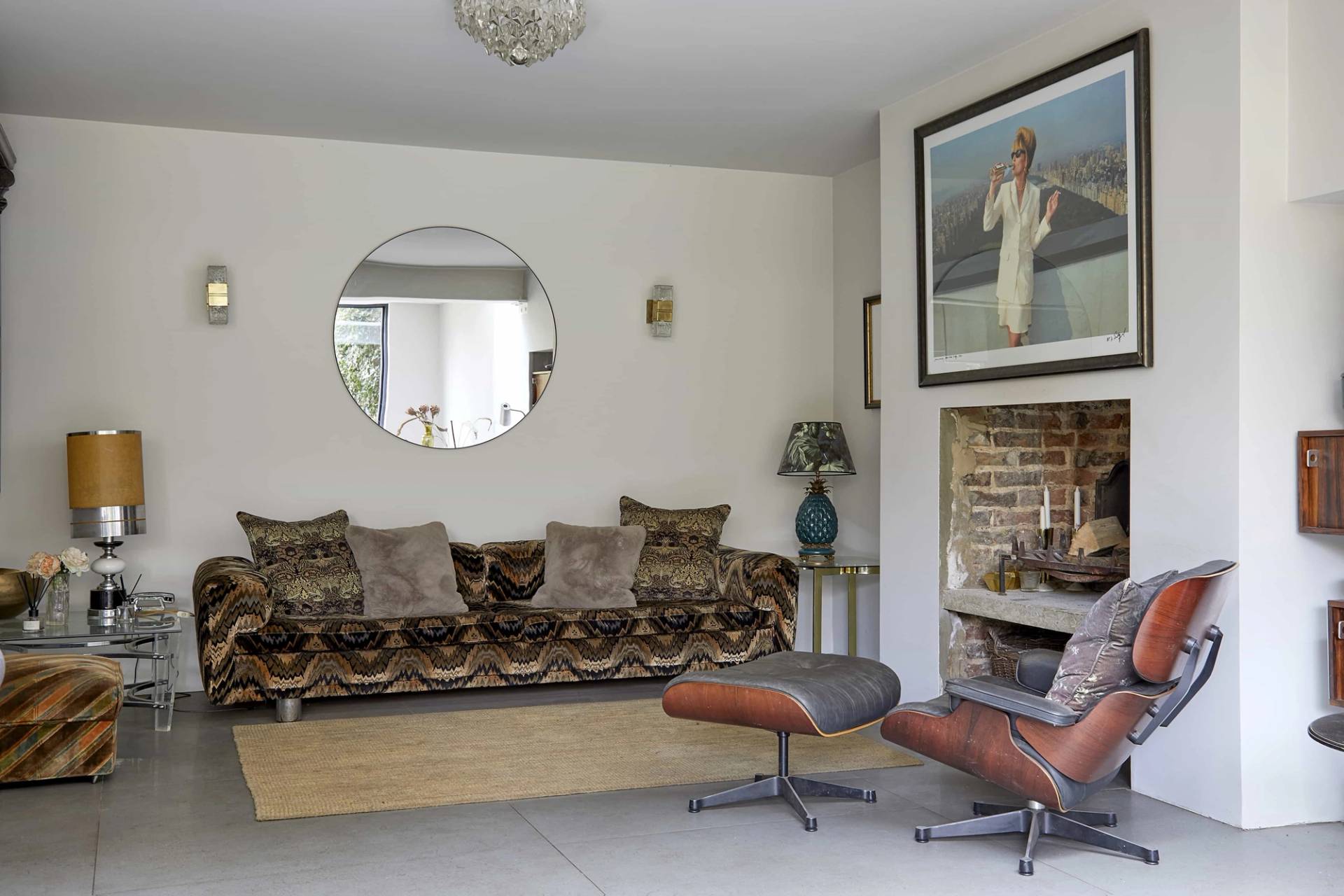 Tiger-print velvet sofa set on polished concrete floors beside an Eames lounge chair and round mirror, Love Locations N16.