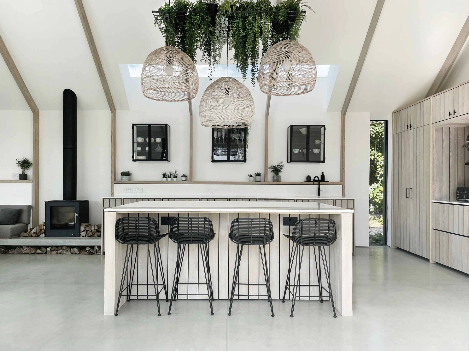 Scandi-style modern kitchen island with black bar stools, woven pendant lights, and vaulted wooden ceilings in a Chichester location home, ideal for culinary commercials, Love Locations PO18.