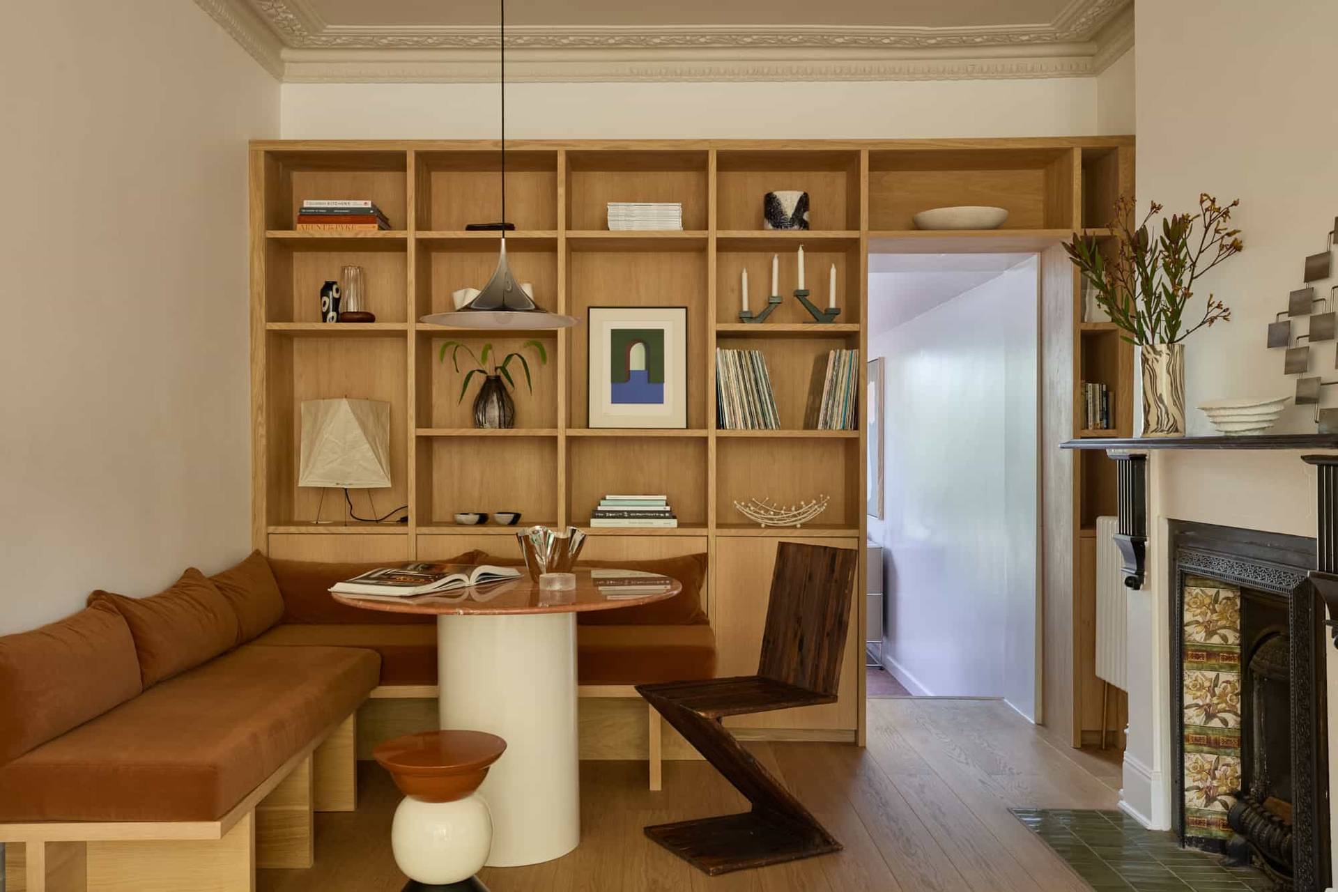 Love Locations boutique dining space SE23: Custom oak panelled booth seating area with a circular marble pedestal dining table, excellent for lifestyle catalog shoots.