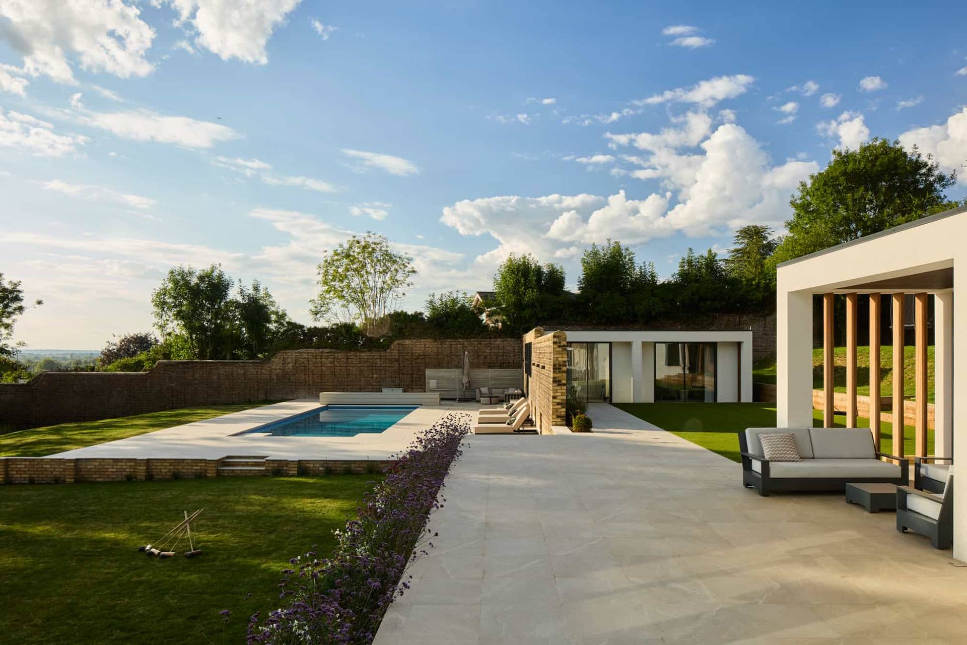Elevated view of a luxury outdoor swimming pool, paved sun deck, and landscaped gardens, perfect for luxury resort lookbooks, Love Locations KT22.