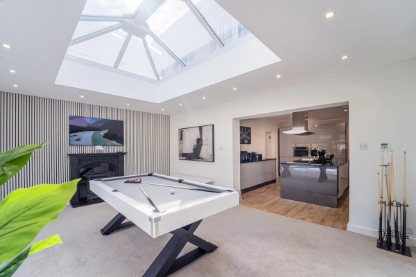 Sunlit garden room glass extension featuring a white pool table set under a roof skylight, Love Locations RM11.