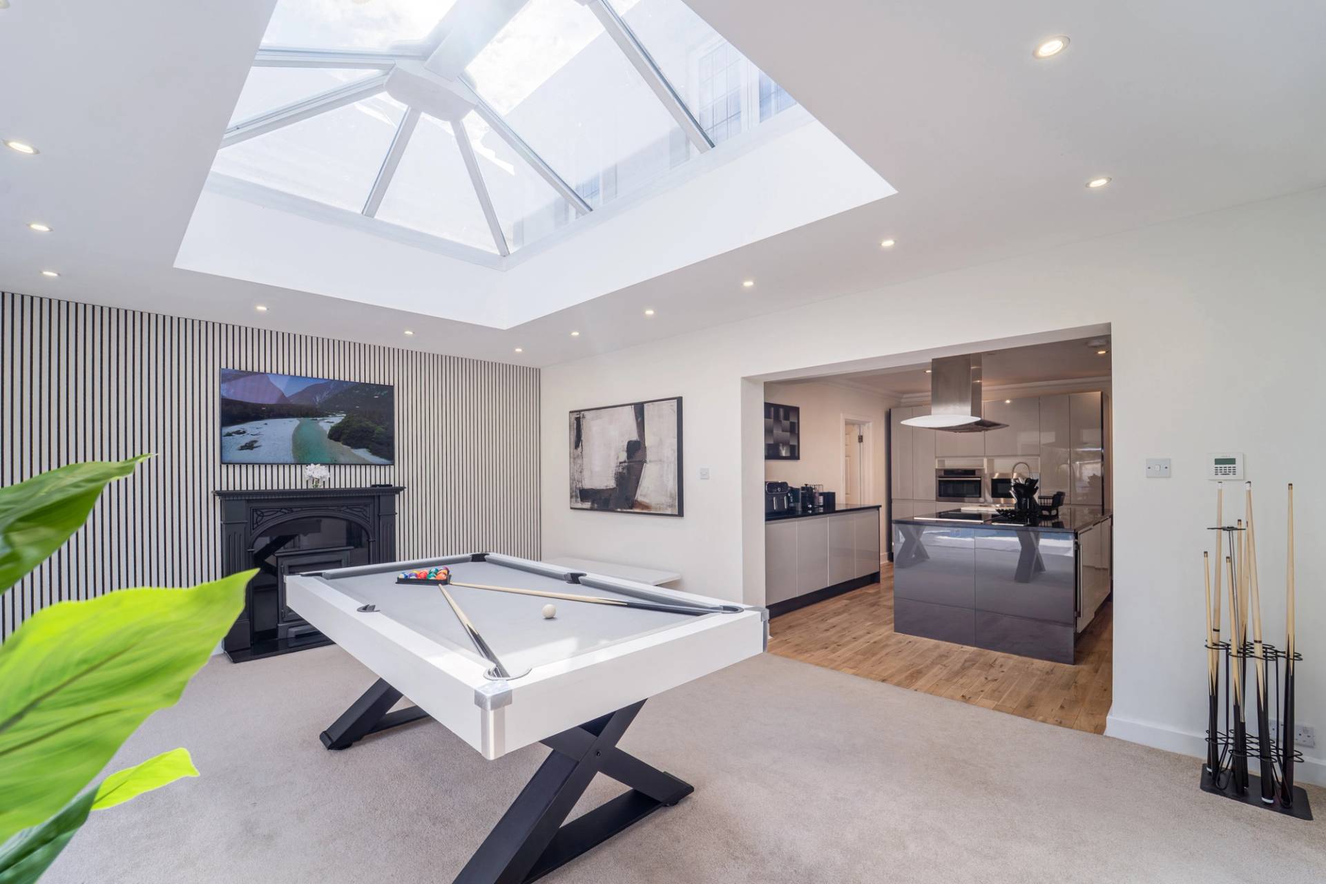 Sunlit garden room glass extension featuring a white pool table set under a roof skylight, Love Locations RM11.