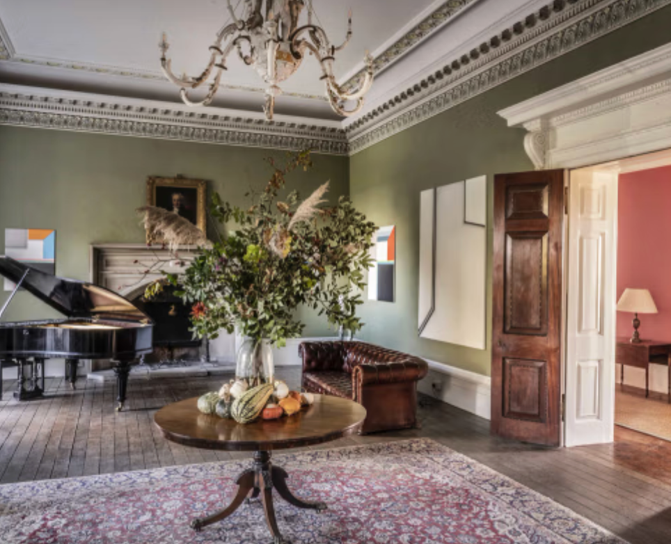 Historic reception room at Keythorpe Hall with piano, floral displays and period features for festive Christmas events.