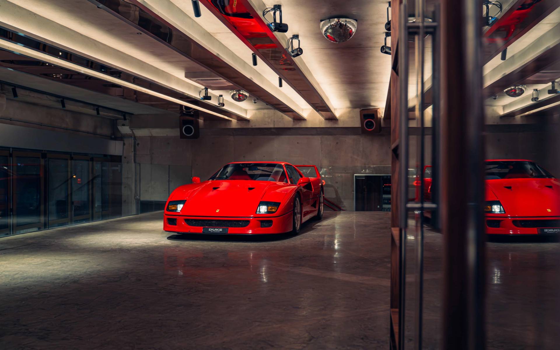 Front view of a red Ferrari F40 under overhead studio strip lights via Love Locations.