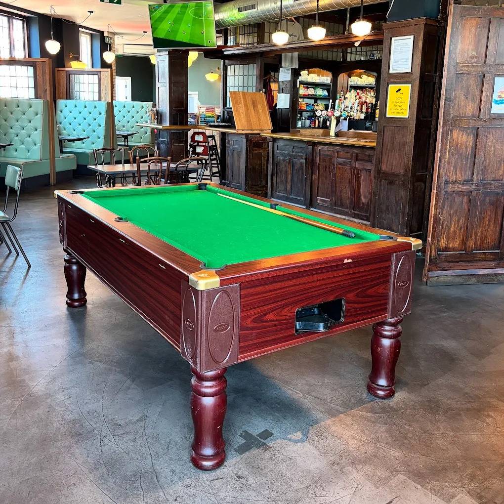 Classic wooden pool table set in a traditional London pub game room shoot space by Love Locations.